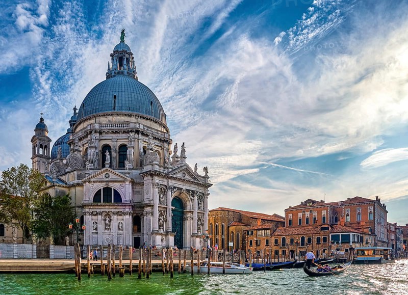 Beautiful view of iconic basilica di Santa Maria della Salute or St Mary of Health and colorful palaces or palazzo by waterfront of Grand Canal
