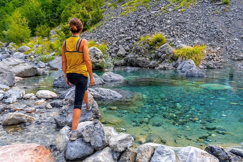 A young woman in the turquoise water reservoir in the valley of Theth national park