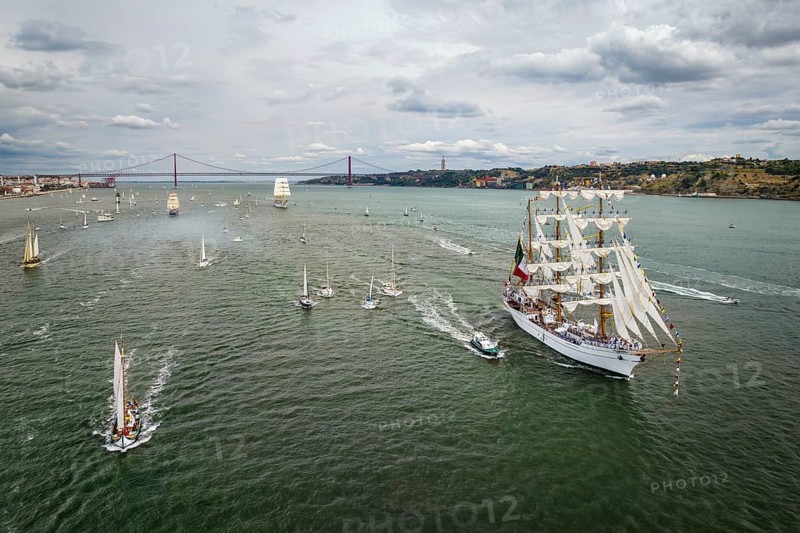 Aerial drone view of tall ships with sails sailing in Tagus river towards the Atlantic ocean in Lisbon