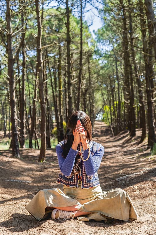 Kali mudra executed in lotus position by a woman in a forest