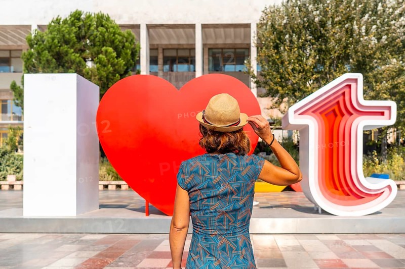 A female tourist at the I Love Tirana sculpture at Skanderbeg Square in Tirana reflected. Albania