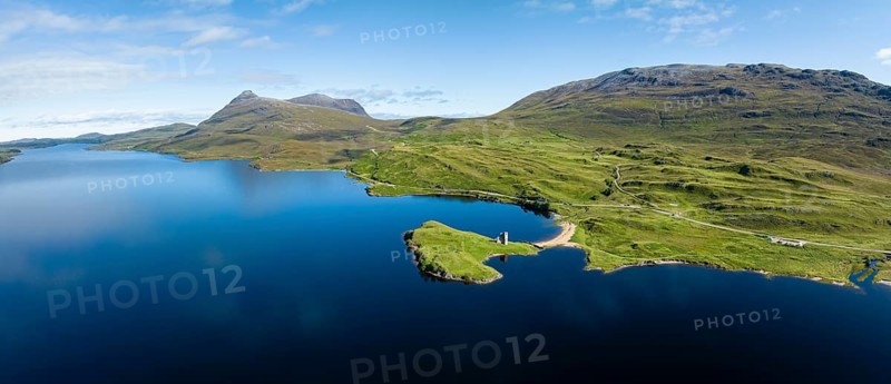 Aerial panorama of the freshwater loch Loch Assynt with the ruins of Ardvreck Castle on a peninsula