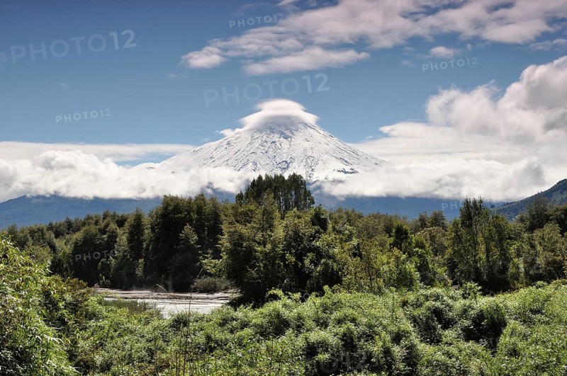 The snow-covered Osorno volcano with a storm cloud at the summit