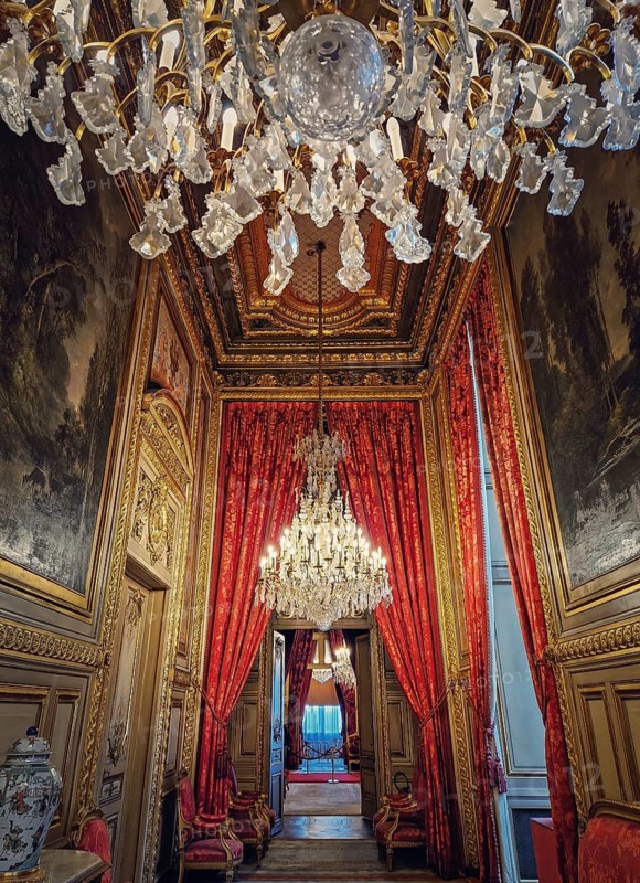 Beautiful decorated Napoleon apartments at Louvre palace. Royal family rooms with cardinal red curtains