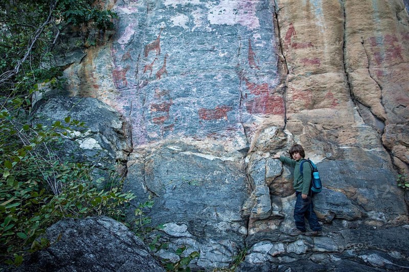 Boy in front of rock rock painting