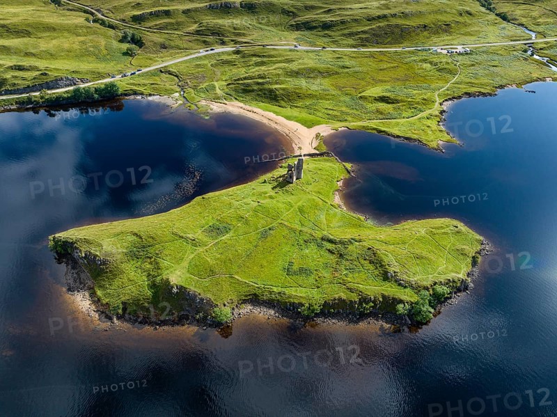 Aerial view of the freshwater loch Loch Assynt with the ruins of Ardvreck Castle on a peninsula