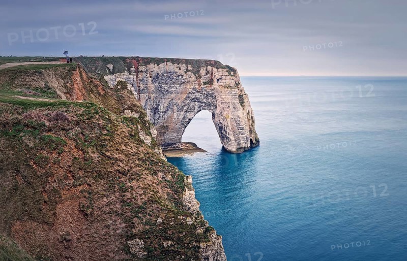 Sightseeing view to the Porte d'Aval natural arch cliff washed by Atlantic ocean waters at Etretat
