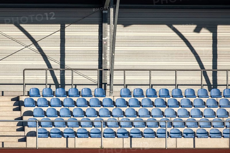 Grandstand with blue seating shells in a sports stadium