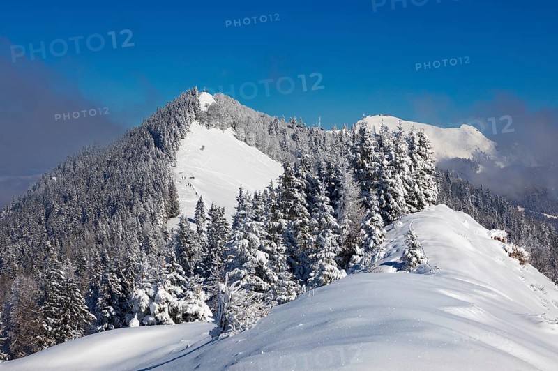 Winter landscape covered in deep snow in the Osterhorn group with a view from Pillstein to Zwoelferhorn