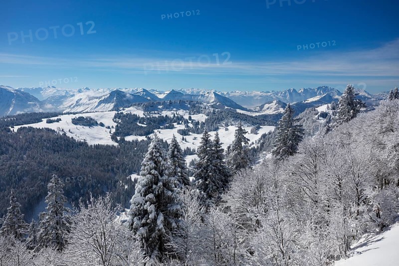 Winter landscape covered in deep snow at the summit of the Zwoelferhorn with a view of the Osterhorn group