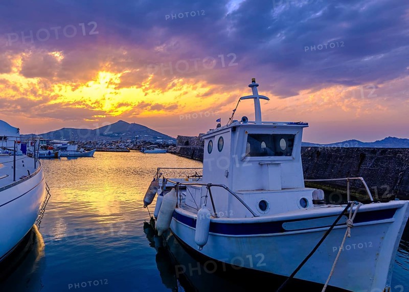 Colorful sunset over quiet Greek fishing village and its harbour
