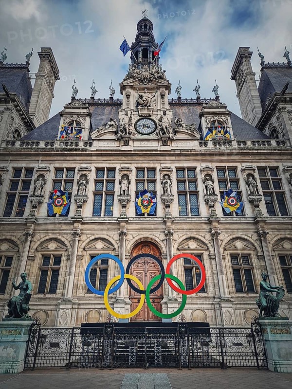 Close up Paris City Hall entrance. Outdoors view to the beautiful ornate facade of the historical building and the olympic games rings symbol in front of the central doors