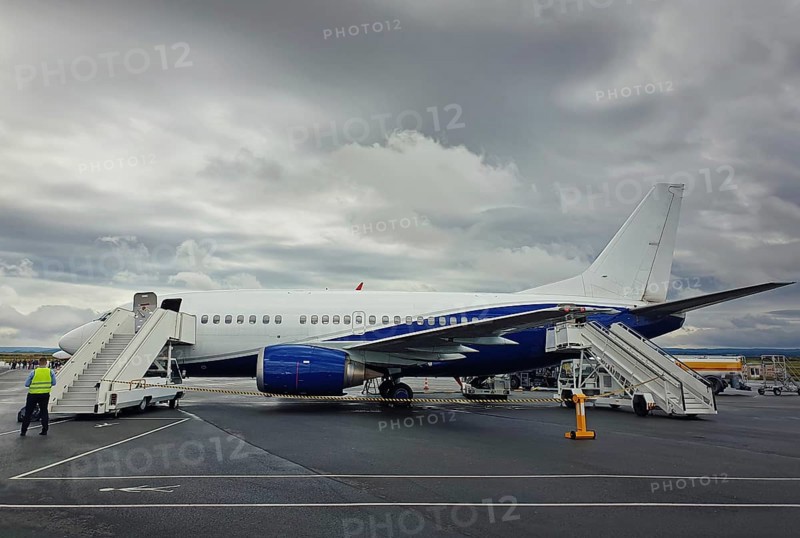 Plane ready for boarding at airport in a cloudy day. Passenger transportation at Charles de Gaulle Airport in Paris. Travel and industry concepts