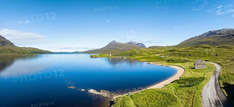 Aerial panorama of the freshwater loch Loch Assynt with the ruins of Ardvreck Castle