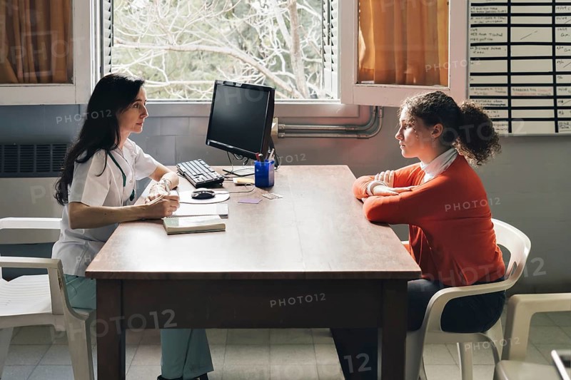 Female physician advising her young patient on contraceptive methods in gynecological consultation