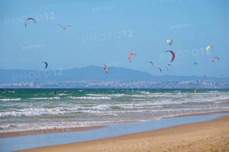 Kiteboarding kitesurfing kiteboarder kitesurfer kites on the Atlantic ocean beach at Fonte da Telha beach