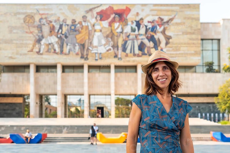 Portrait of a tourist woman at the entrance to the National Historical Museum in Skanderbeg Square in Tirana. Albania