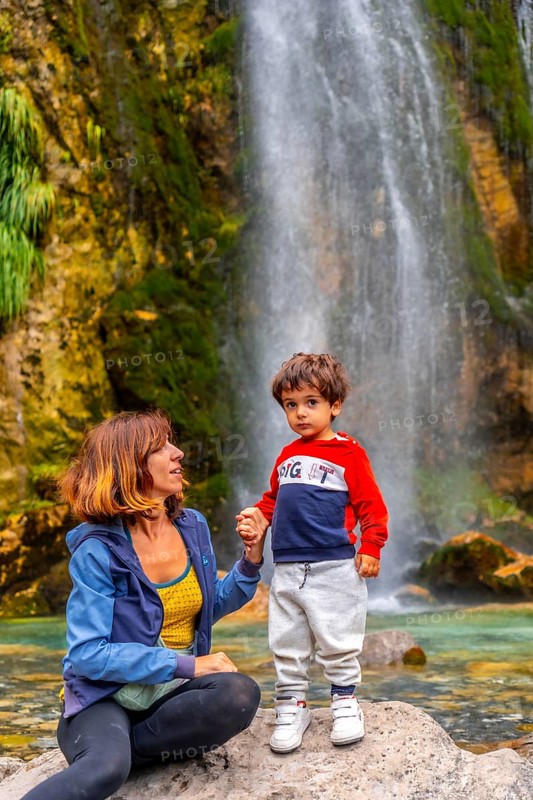Portrait of mother with her son Grunas waterfall of Theth national park in summer