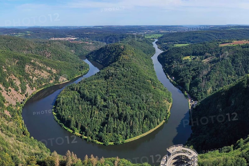 Aerial view of the Saar Loop. The Saar winds through the valley and is surrounded by green forests. Orscholz
