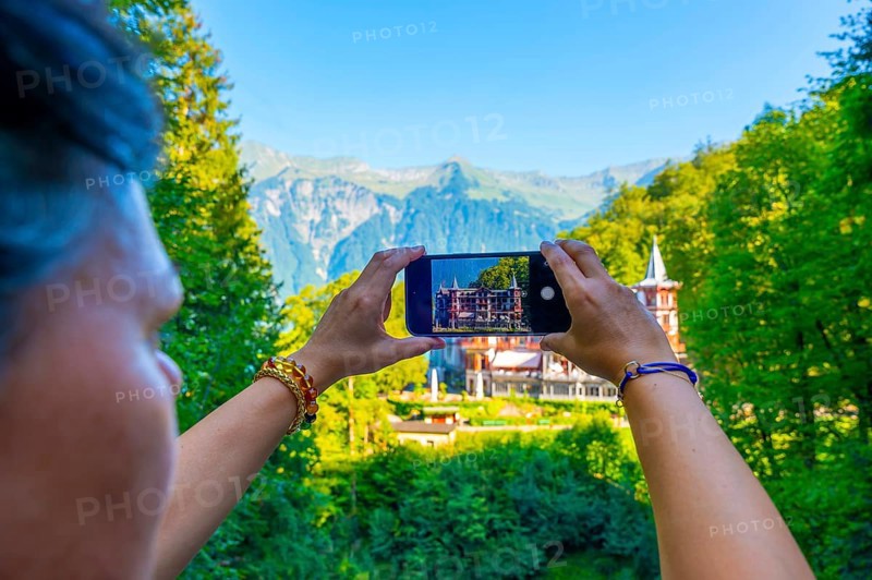 Woman Photographing The Historical Grandhotel Giessbach on the Mountain Side in Brienz