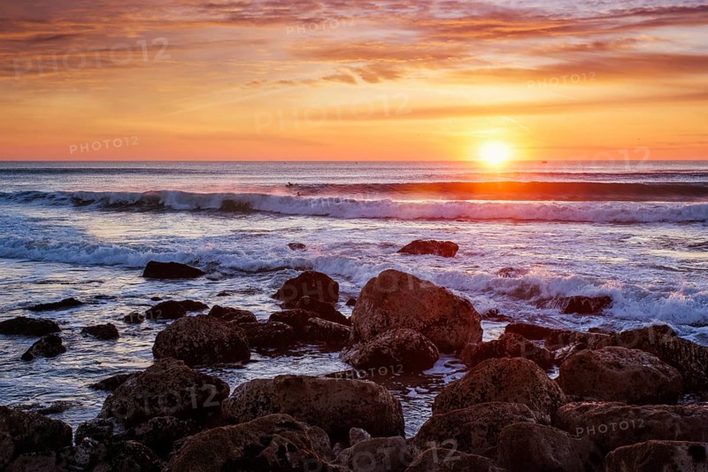 Atlantic ocean sunset with waves and rocks at Costa da Caparica