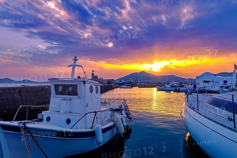 Colorful sunset over quiet Greek fishing village and its harbour