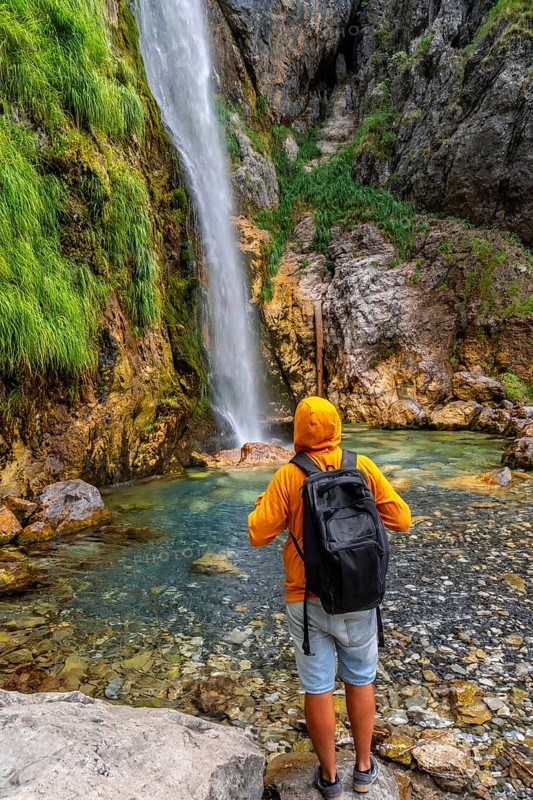 Hiker at Grunas waterfall in Theth national park