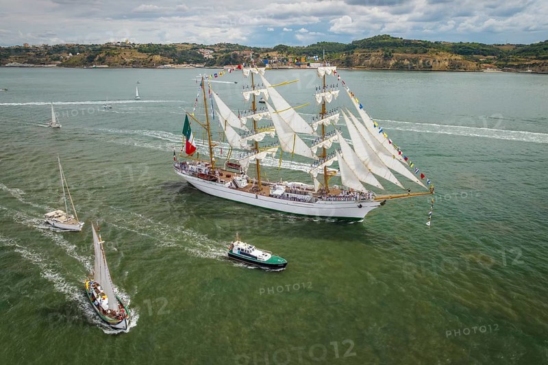 Aerial drone view of tall ships with sails sailing in Tagus river towards the Atlantic ocean in Lisbon