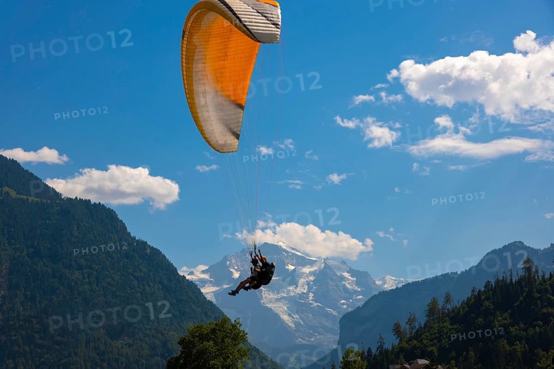 Paragliding in Front Of Snow Capped Jungfraujoch Mountain in a Sunny Day in Interlaken