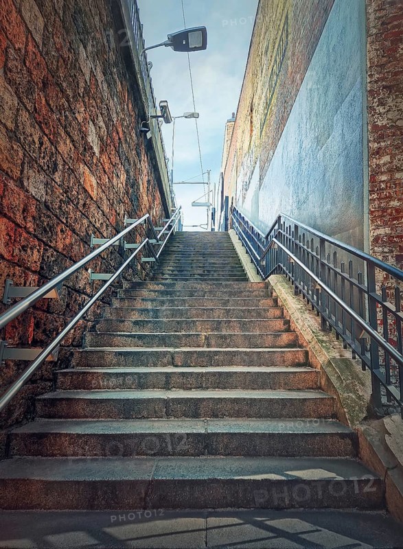Narrow outside stairway between the walls. Abstract view upstairs
