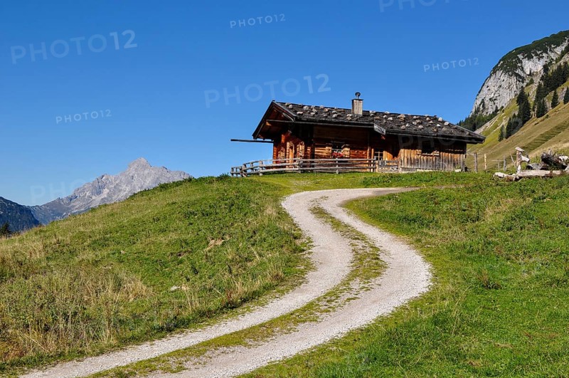 One of the rustic alpine huts on the Kallbrunnalm in the Berchtesgaden Alps with the Loferer Steinberge in the background