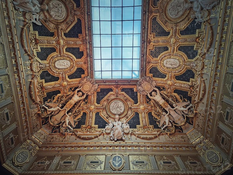 Golden ceiling with architectural details of the Salon Carre inside Louvre museum