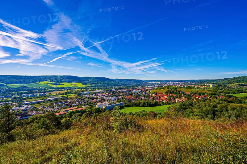 View over the city of Jena from the Galgenberg with the Kernberge in the background under blue sky and veil clouds