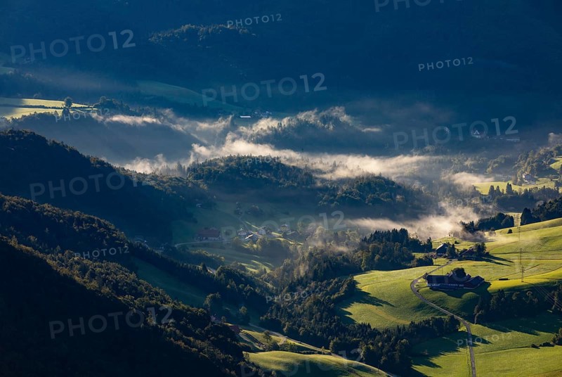 Farms at sunrise and morning fog near Ebenau