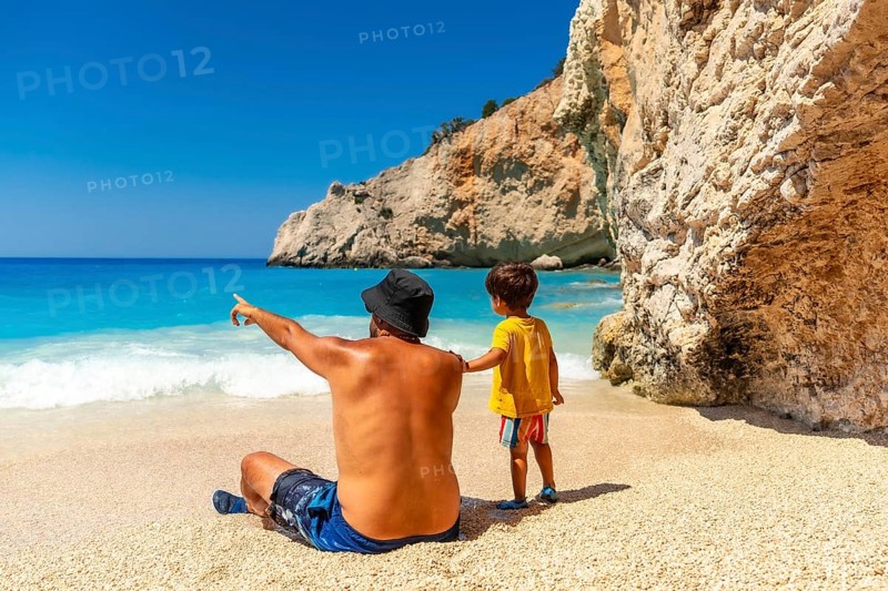 A father and child having fun on Porto Katsiki beach in summer vacation Lefkada island