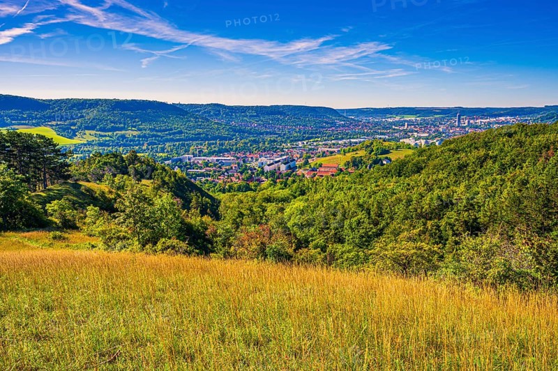 View over the city of Jena from the Galgenberg with the Kernberge in the background under blue sky and veil clouds
