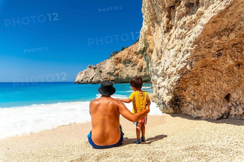 A father and child having fun on Porto Katsiki beach in summer vacation Lefkada island