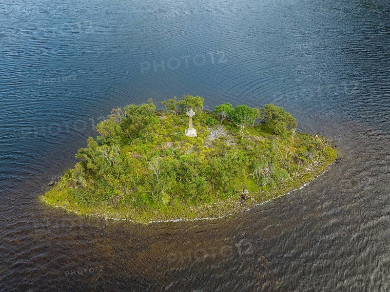 Aerial view of a small island with a Celtic stone cross in the freshwater loch of Loch Stack in the Northern Highlands