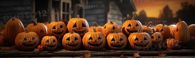 Spooky and fun collection of dozens of halloween carved pumpkins outside on hallows eve
