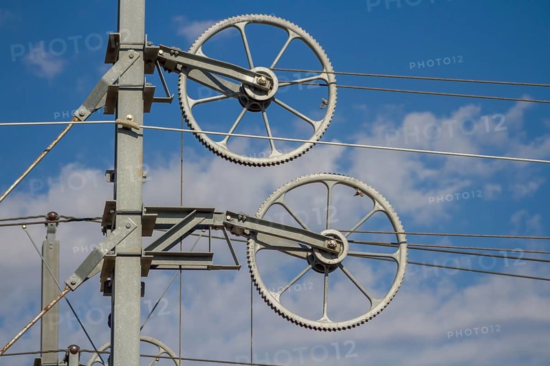 Railway line mast with wheel tensioning station