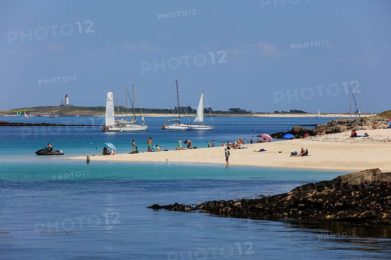Sandy beach beach with bathers and sailboats