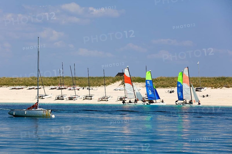 Sandy beach beach of the island Ile de Penfret with catamarans of the sailing school Les Glenans