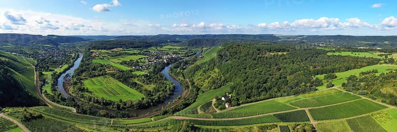 Wiltinger Saarbogen. The river winds through the valley and is surrounded by vineyards and green forests. Kanzem