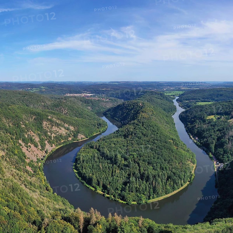 Aerial view of the Saar Loop. The Saar winds through the valley and is surrounded by green forests. Orscholz