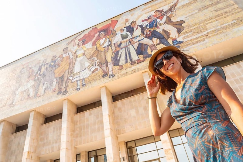 Portrait of a tourist woman at the entrance to the National Historical Museum in Skanderbeg Square in Tirana. Albania