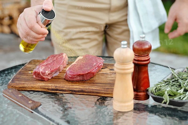 Sprinkling club beef steak with olive oil