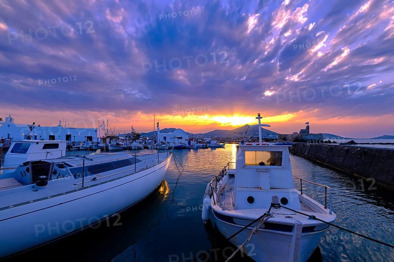 Colorful sunset over quiet Greek fishing village and its harbour