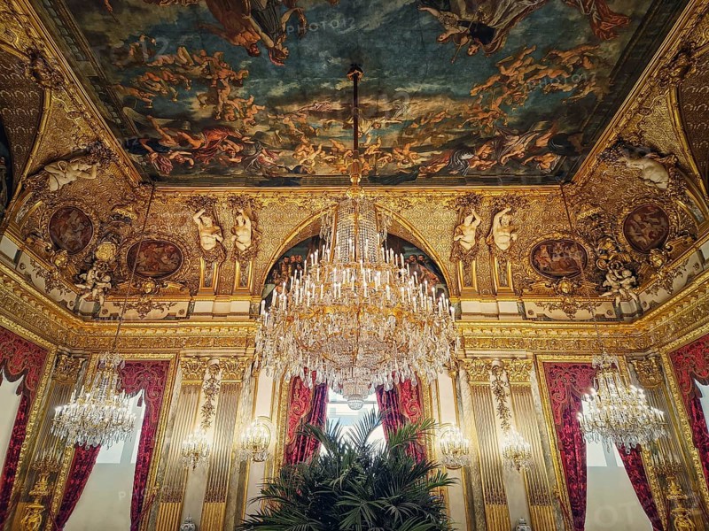 Beautiful decorated Napoleon apartments at Louvre palace. Royal family rooms with cardinal red curtains
