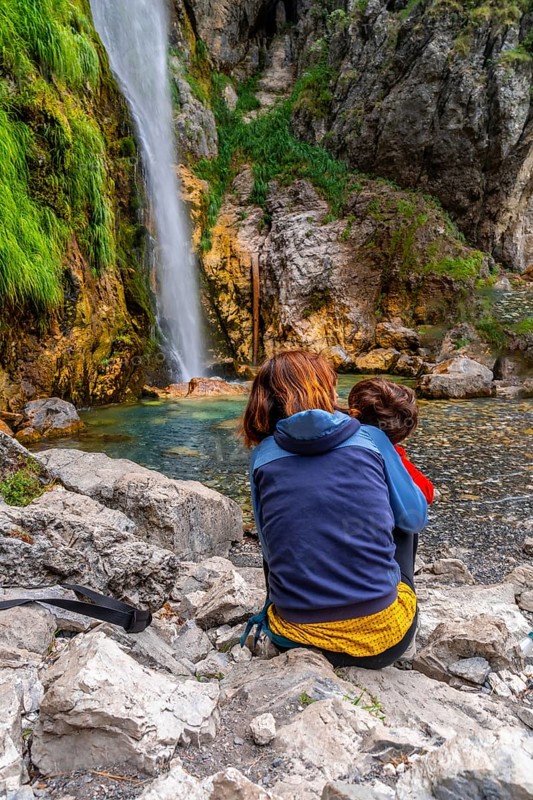 Woman with her child at Grunas waterfall in Theth national park