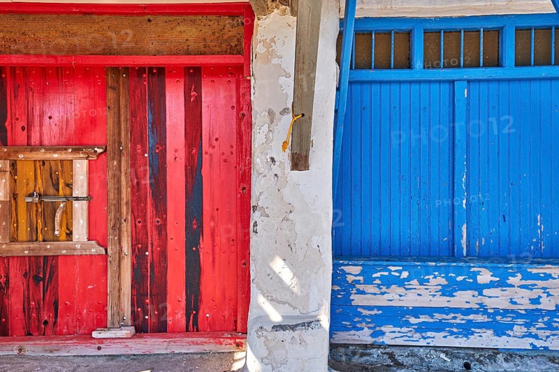 Colorful blue and red boat garage doors in Klima fishermen village